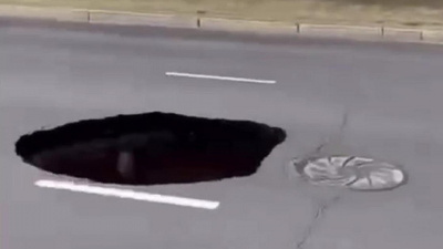 "Вход в преисподнюю": огромная яма образовалась в центре дороги в Павлодаре (видео)